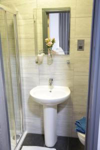 a bathroom with a white sink and a mirror at Park City Rooms in Manchester