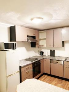 a kitchen with white cabinets and a stove top oven at My-Skypalace Neckarsulm in Neckarsulm