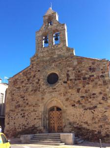 an old stone church with a steeple and a door at Apartamento Maracaibo in Astorga