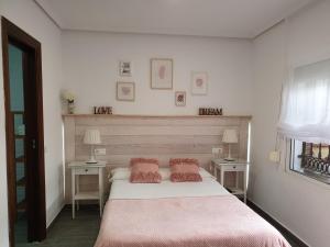 a bedroom with a bed with two tables and two lamps at El Nogal Home in Málaga