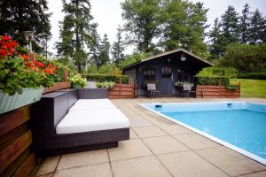 a swimming pool with a bench next to a house at Fletcher Hotel Restaurant Beekbergen-Apeldoorn in Beekbergen