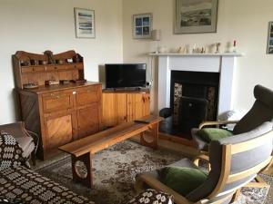 a living room with a tv and a fireplace at Valtos 23 Isle of Lewis in Uig