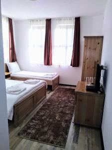 a room with two beds and a desk and window at Guesthouse White Margarit in Melnik