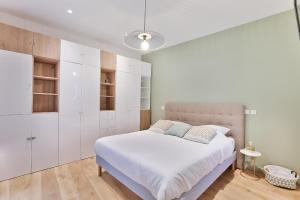 a white bedroom with a large bed and white cabinets at HR Quai Augustins - Notre Dame Paris in Paris