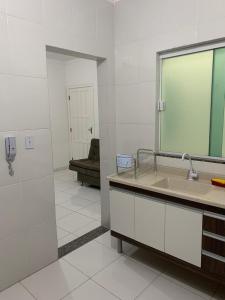 a bathroom with a large mirror and a sink at Edf. Odilon Vieira dos Santos in Vitória da Conquista