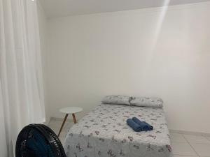 ein Bett mit zwei blauen Socken auf einem Zimmer in der Unterkunft Edf. Odilon Vieira dos Santos in Vitória da Conquista