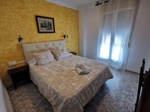 Un dormitorio con una cama con un par de zapatos. en Hotel Doña Carmen, en Ronda