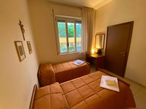 una camera da letto con due letti e una finestra di Casa per Ferie Sant'Anna a Matera