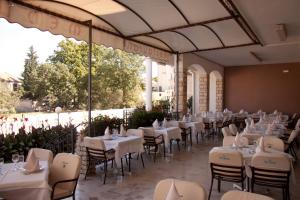un restaurante con mesas y sillas blancas en un edificio en HOTEL MEDUZA en Biograd na Moru