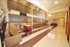 a lobby with a waiting room with couches and tables at Hotel K Square in Kolhapur