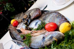 a plate of fish and vegetables on a table at HOTEL MEDUZA in Biograd na Moru