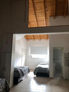 une chambre avec deux lits et un plafond en bois dans l'établissement Ruffus's Apple Cipolletti, à Cipolletti