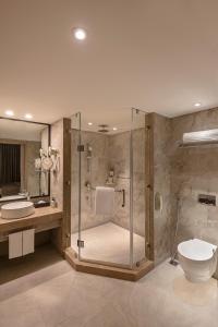 La salle de bains est pourvue d'une douche, de toilettes et d'un lavabo. dans l'établissement Lemon Tree Premier, New Town, Kolkata, à Kolkata