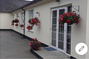 una casa con flores a un lado. en Mullaghbeag Lodge en Navan