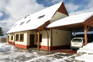 um edifício coberto de neve com um carro estacionado no exterior em Chalupa Bella em Zamberk