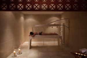 a person laying in a shower in a bath room at Jolie Ville Hotel & Spa Kings Island Luxor in Luxor