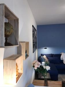 een woonkamer met een blauwe bank en een blauwe muur bij LLN lodge in Louvain-la-Neuve