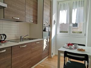 a kitchen with wooden cabinets and a table with a plate of food at Italianflat - Arena di Verona, Elegant 2 Bedrooms in Verona