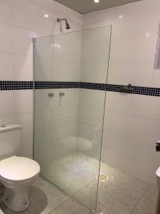 uma casa de banho com uma cabina de duche em vidro e um WC. em Motel Sky (Adults Only) em Salvador