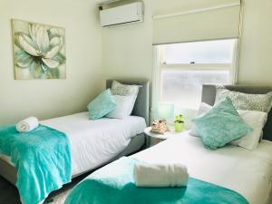 um quarto com 2 camas em azul e branco em Melbourne Inner City Holiday Home Near CBD & Flemington em Melbourne