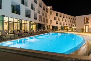 a swimming pool in front of a building at night at Hotel Olea in Novalja