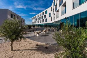 een gebouw met tafels en stoelen buiten bij Hotel Olea in Novalja