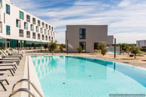 a large swimming pool in front of a building at Hotel Olea in Novalja