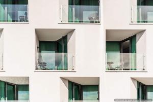 a building with windows with chairs in it at Hotel Olea in Novalja