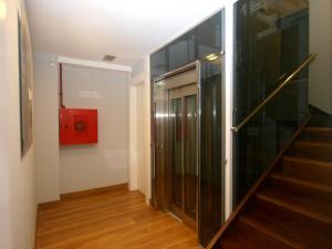 a hallway with a staircase and a red box on the wall at Hosteria Santander in Santander