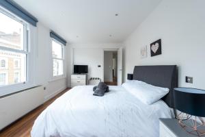 ロンドンにあるGorgeous Apartment by Hyde Park (SS4)の白いベッドルーム(大型ベッド1台、窓2つ付)