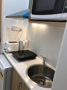 a kitchen counter with a sink and a microwave at Melbourne short stay- Burwood Deakin Uni墨尔本民宿-迪肯大学Burwood in Burwood