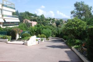 einen Gehweg in einem Garten mit einem Gebäude und Bäumen in der Unterkunft B&B Villa Feline in Cannes