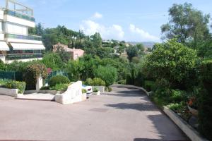 a walkway in a garden with a building and trees at B&B Villa Feline in Cannes