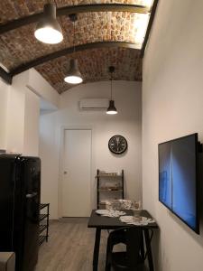 jadalnia ze stołem i zegarem na ścianie w obiekcie DOMUSCUNEO Barra di Ferro 3 bianco w mieście Cuneo