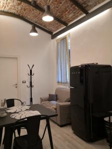 a living room with a table and a refrigerator at DOMUSCUNEO Barra di Ferro 3 bianco in Cuneo