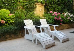 zwei weiße Stühle auf einer Terrasse mit Blumen in der Unterkunft B&B Villa Feline in Cannes + 11 Fotos