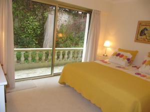 a bedroom with a yellow bed and a large window at B&B Villa Feline in Cannes