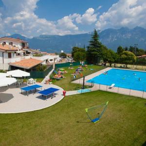a large swimming pool with people sitting around it at Agriturismo Al Lambic in Tignale