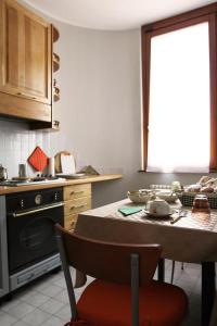 cocina con fogones y mesa con silla en B&B Margè, en Oltrona di San Mamette