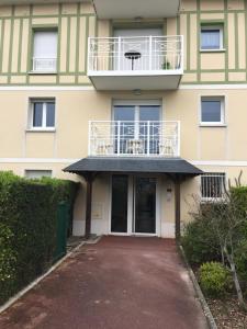ein Gebäude mit einem Balkon auf dem Dach in der Unterkunft Vallon 3 pièces avec balcon in Trouville-sur-Mer