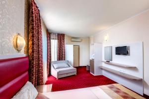 a hotel room with a couch and a television at Hotel Capri in Nesebar