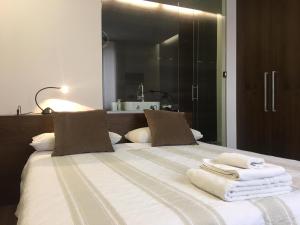 1 dormitorio con 1 cama con toallas en B&B Margè, en Oltrona di San Mamette