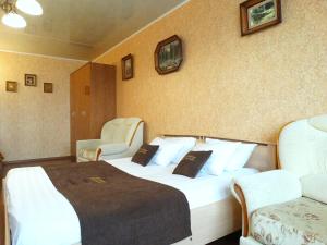 a hotel room with a large bed and two chairs at Inndays on 9 Maya in Tula