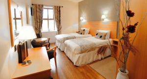 a hotel room with two beds and a desk at The Coach House Hotel in Oranmore
