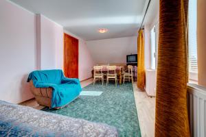 a room with a bed and a chair and a table at Guest house Padine Zlatibora in Zlatibor