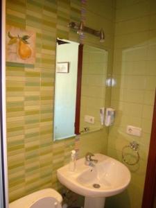 uma casa de banho com um lavatório, um WC e um espelho. em La Fuente de la Covatilla em La Hoya
