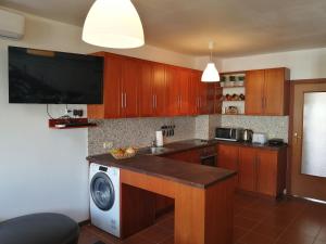 eine Küche mit Holzschränken, einer Waschmaschine und einem Trockner in der Unterkunft INFINITY Blue 2 in Burgas City