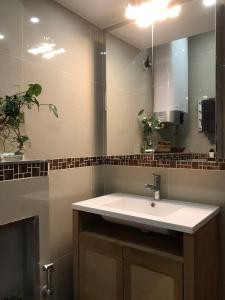 uma casa de banho com um lavatório e um espelho em Chambre via Natina em Saint-Germain-en-Laye