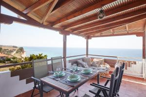 una mesa y sillas en un balcón con vistas al océano en Thea Suites Potidea, en Nea Potidaea