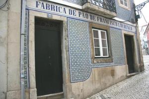 un edificio con una puerta negra y azulejos azules. en Madragoa Cosy Apartment, en Lisboa